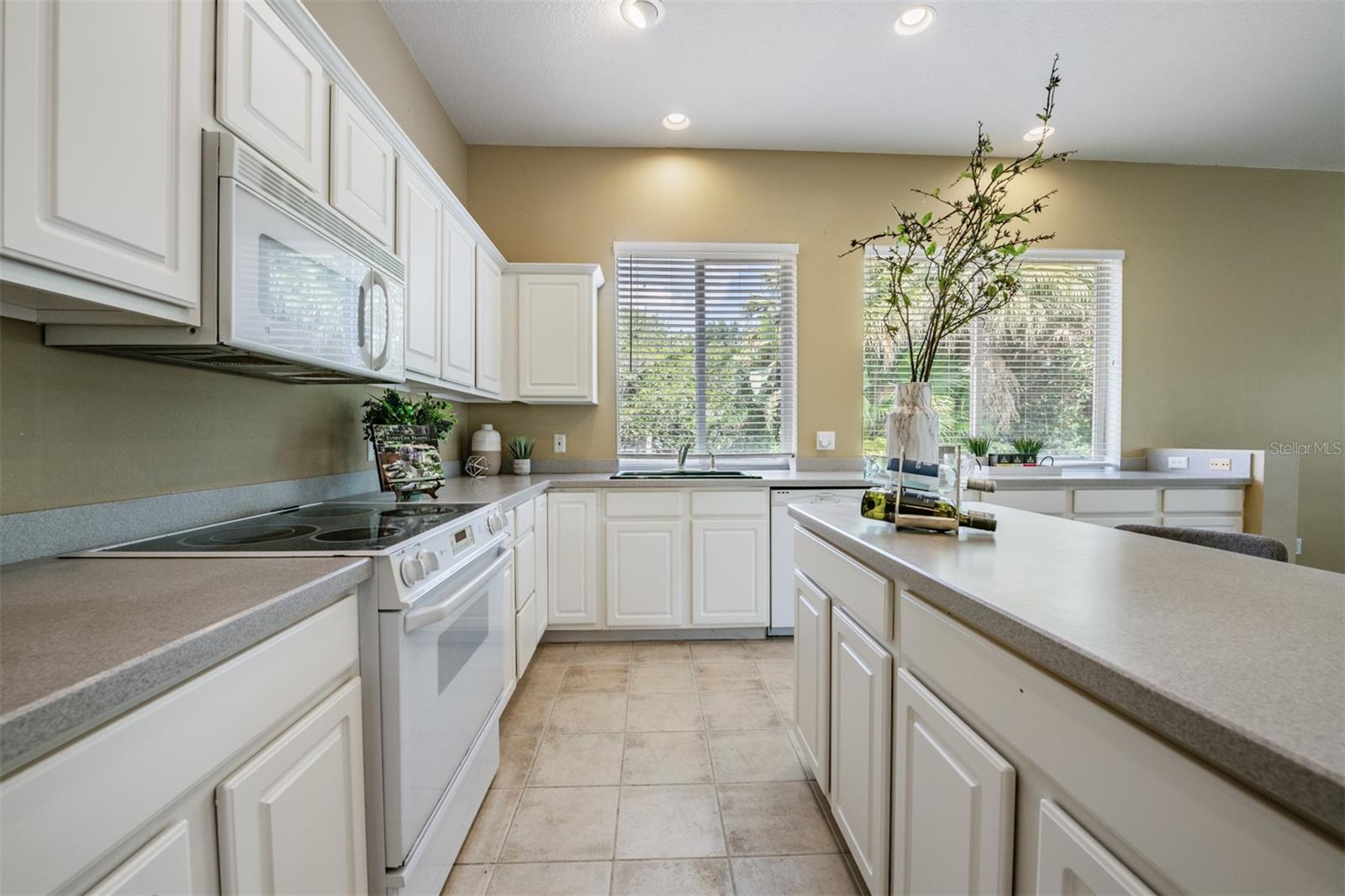 Spacious and open kitchen, tile flooring and corian countertops