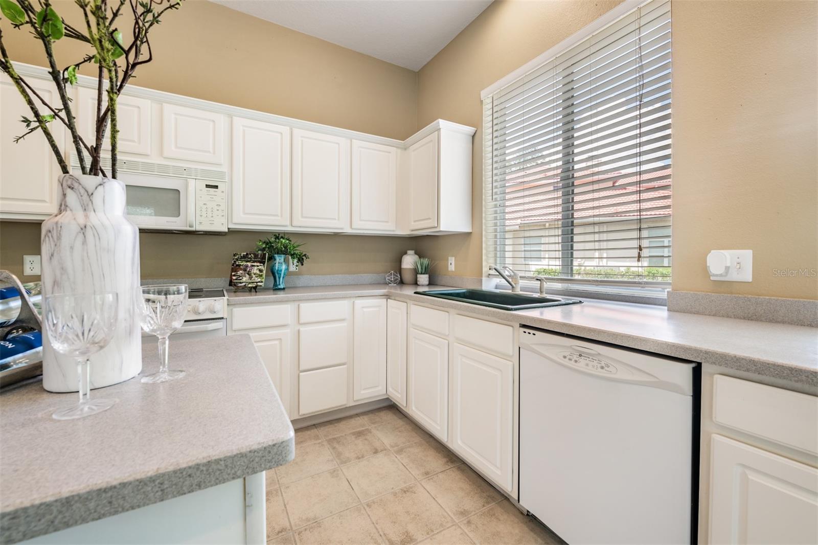 Spacious and open kitchen, tile flooring and corian countertops