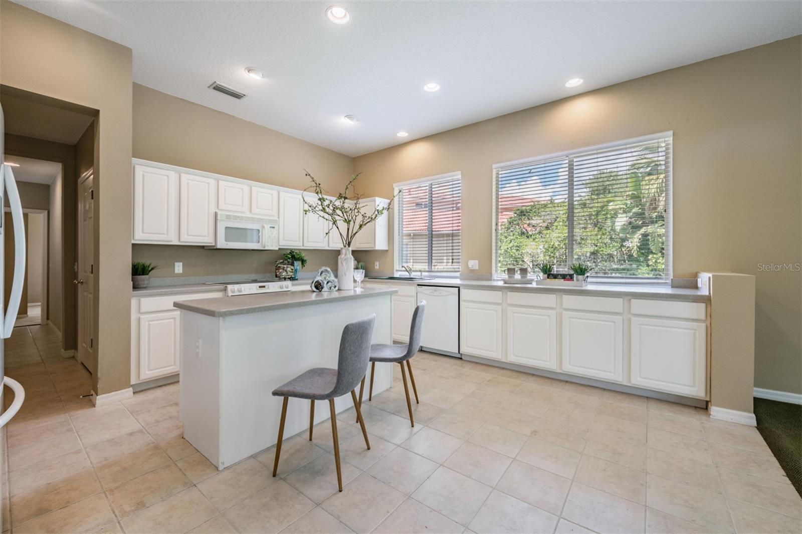 Spacious and open kitchen, tile flooring and corian countertops