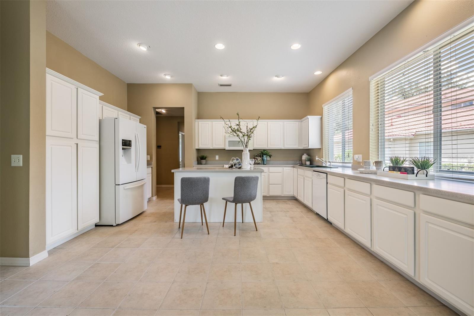 Spacious and open kitchen, tile flooring and corian countertops