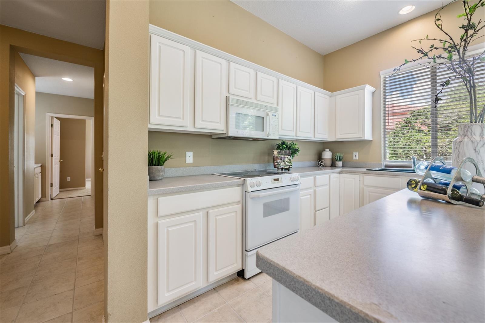 Spacious and open kitchen, tile flooring and corian countertops