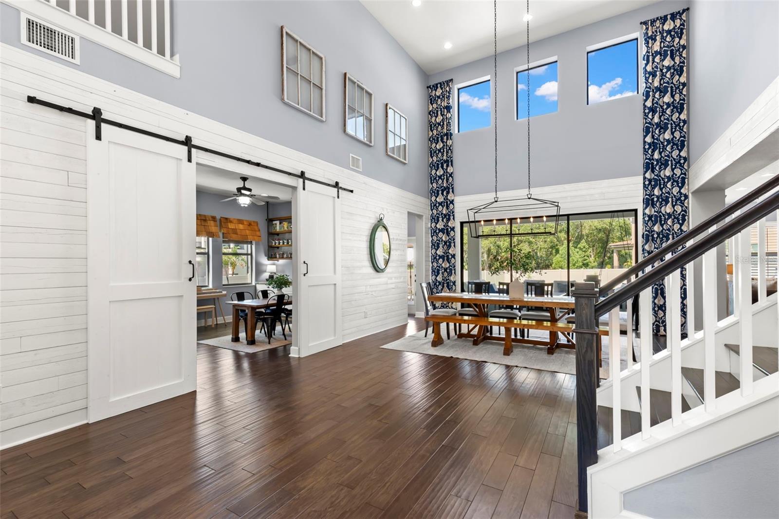 Barn doors open to den with built in cabinets and shelves