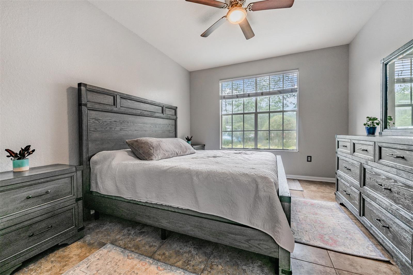 Master Bedroom, tile flooring and ceiling fan with light - all new paint throughout the condo.