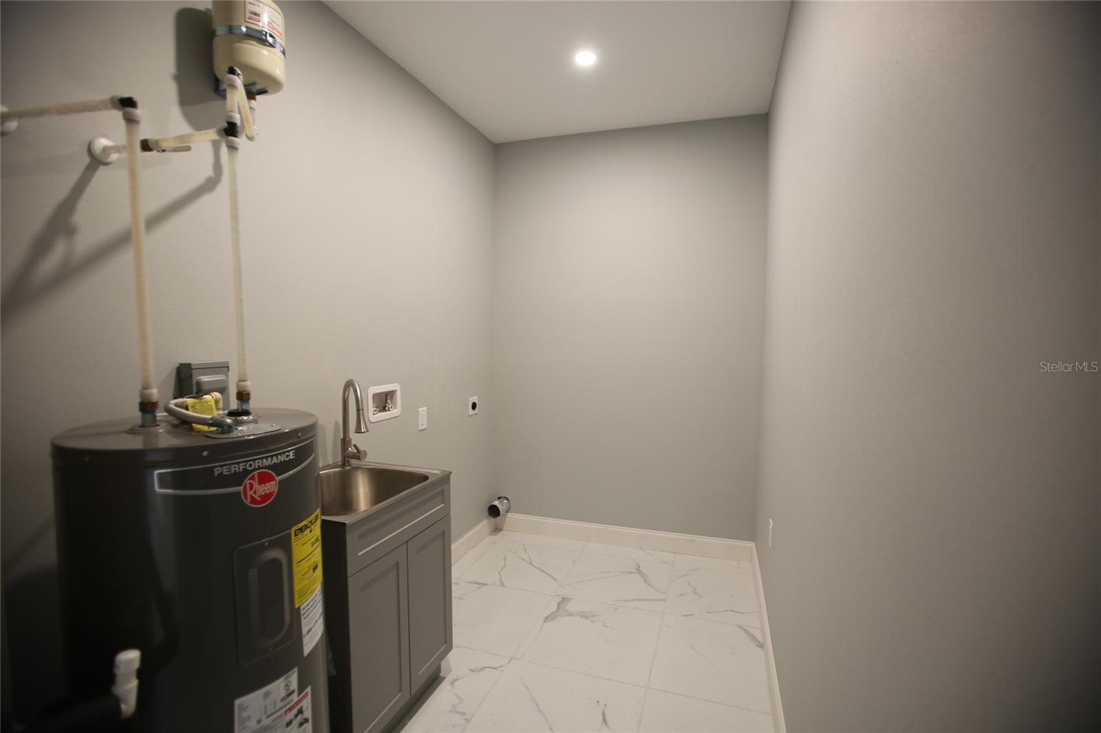 Laundry room with water heater and utility sink