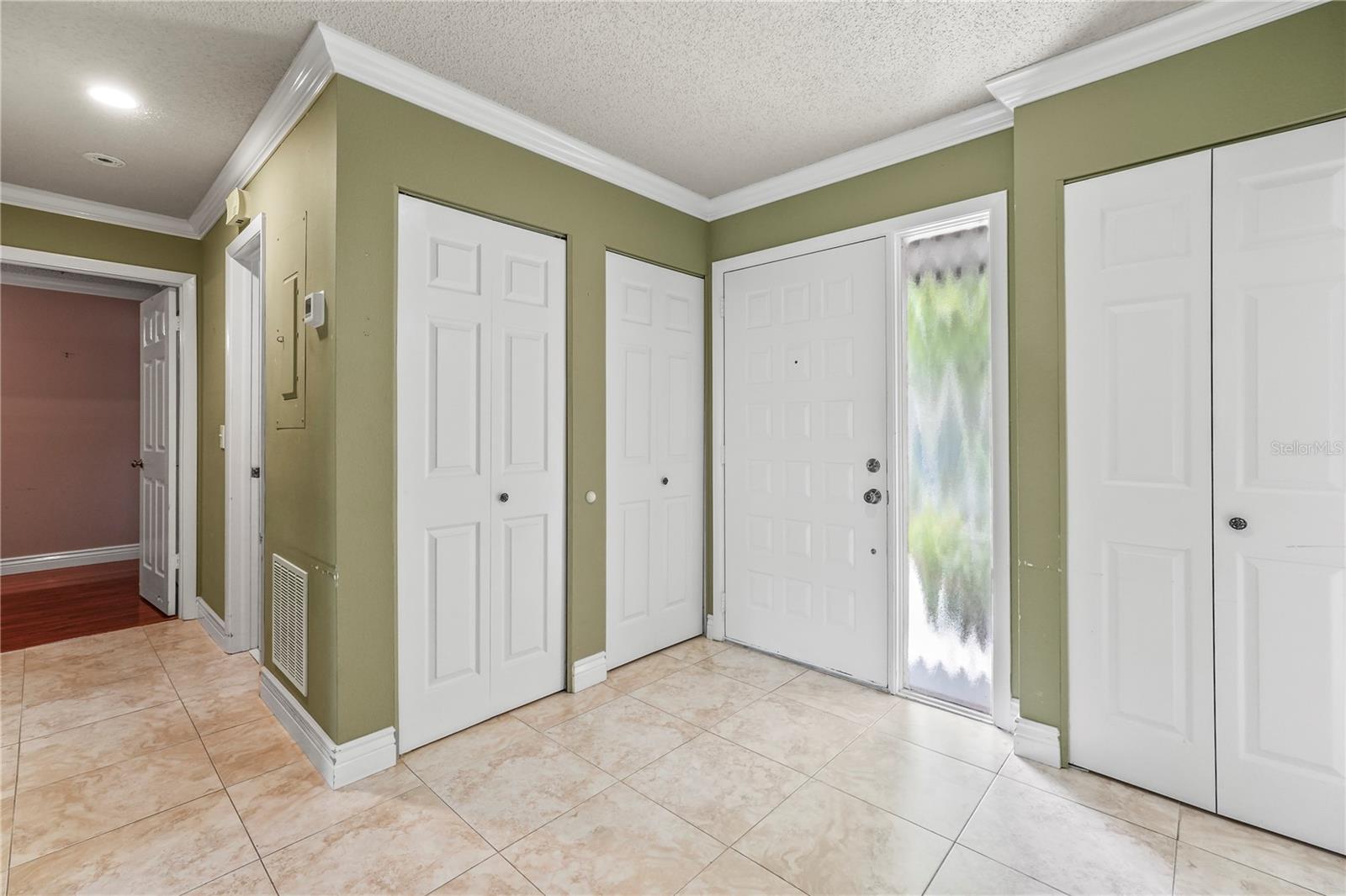 Front door, utility closet and coat closet