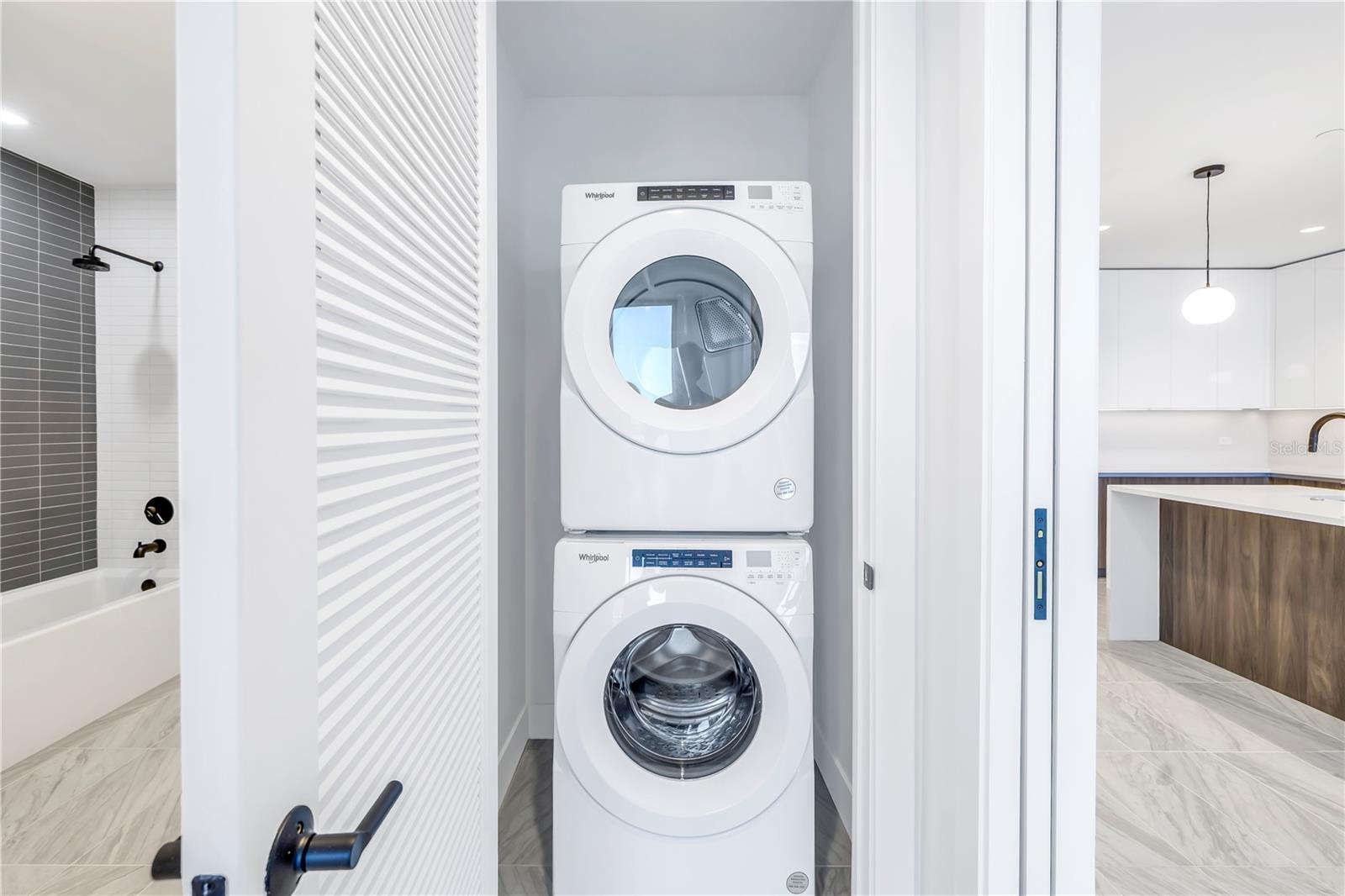 Laundry closet and entry to full bath and primary bedroom