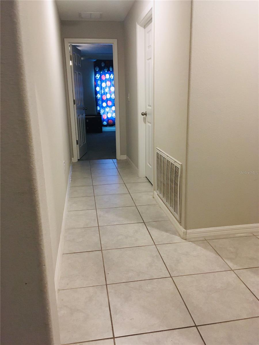 View of the walkway towards the separate laundry room on the right and Bedroom #4 straight ahead