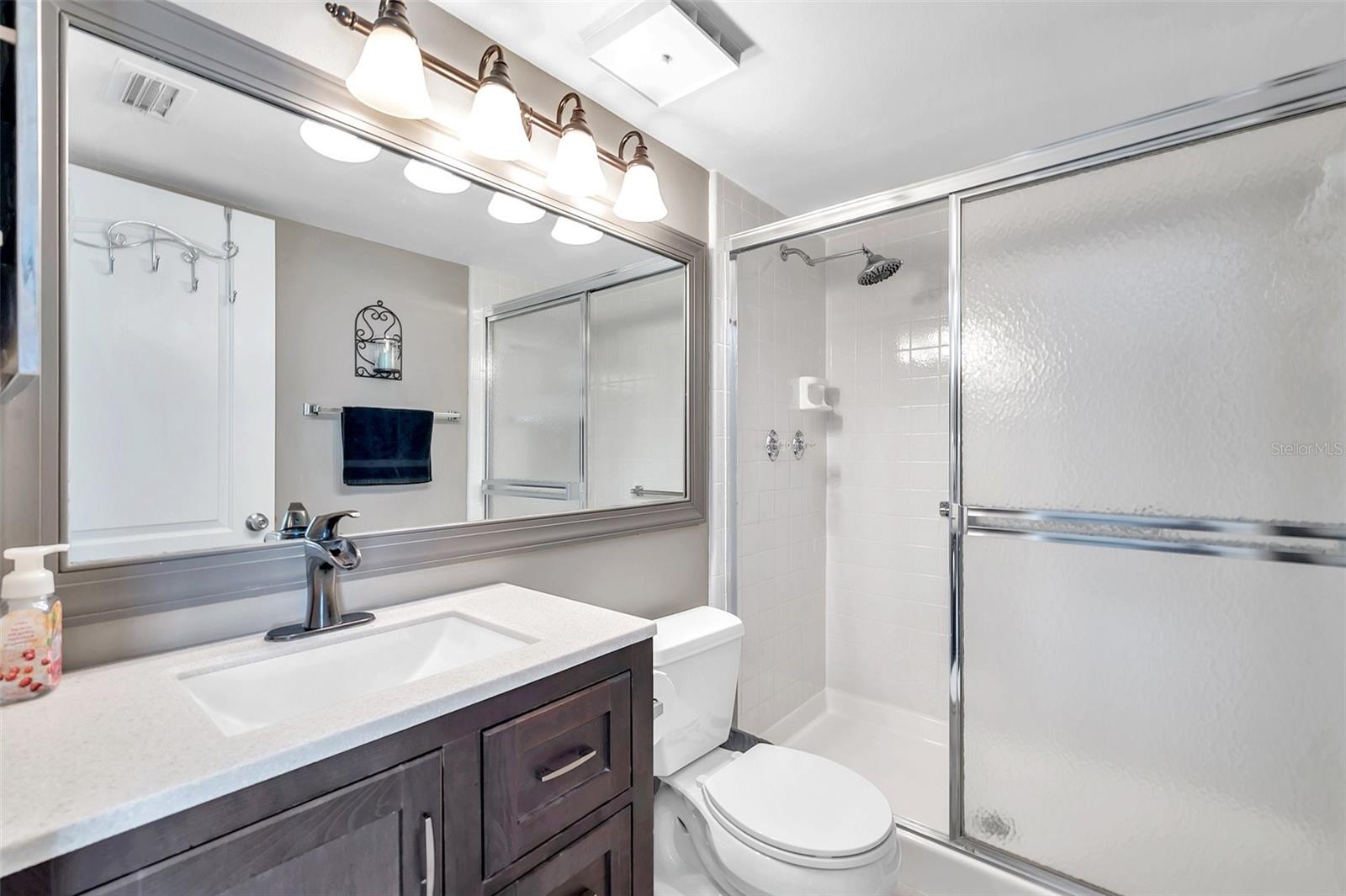 En-Suite bathroom in Primary bedroom with updated vanity, mirror and a walk in shower