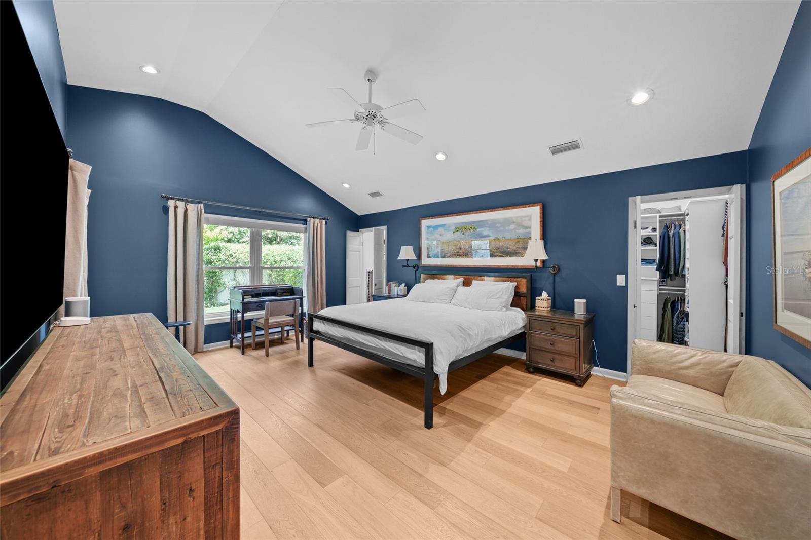 Primary bedroom offers vaulted ceilings and two walk in closets