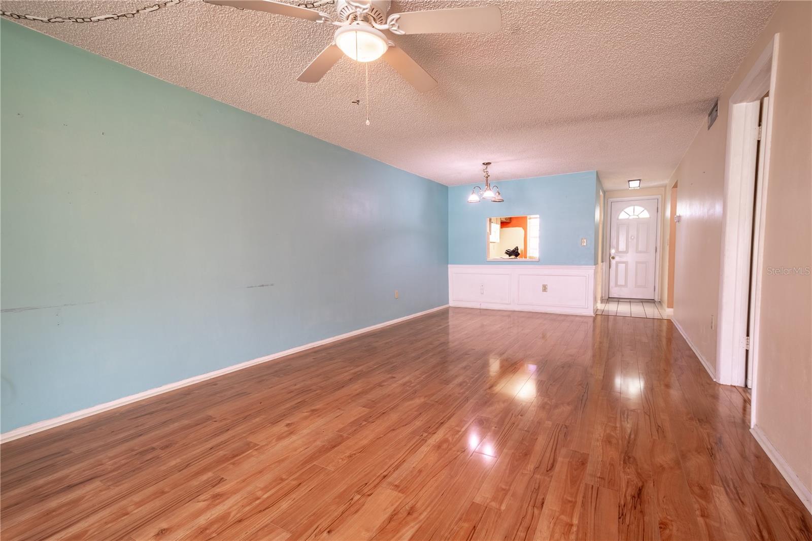 The living room is light and bright with natural daylight coming in through the sliding glass doors.