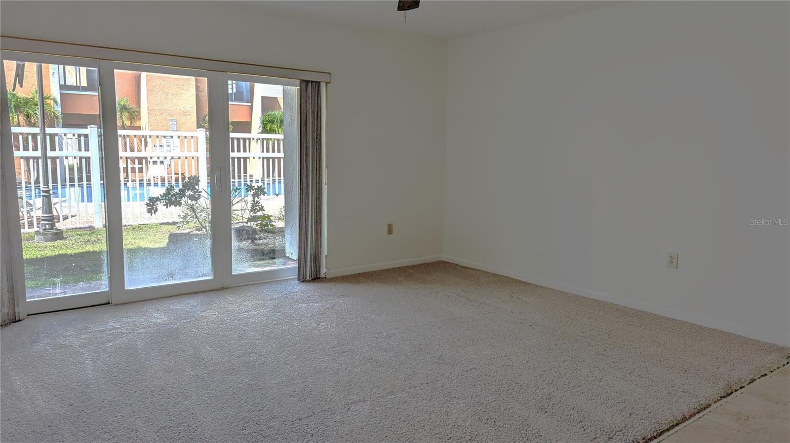 Another view of Living Room, storage closet on patio. View of pool