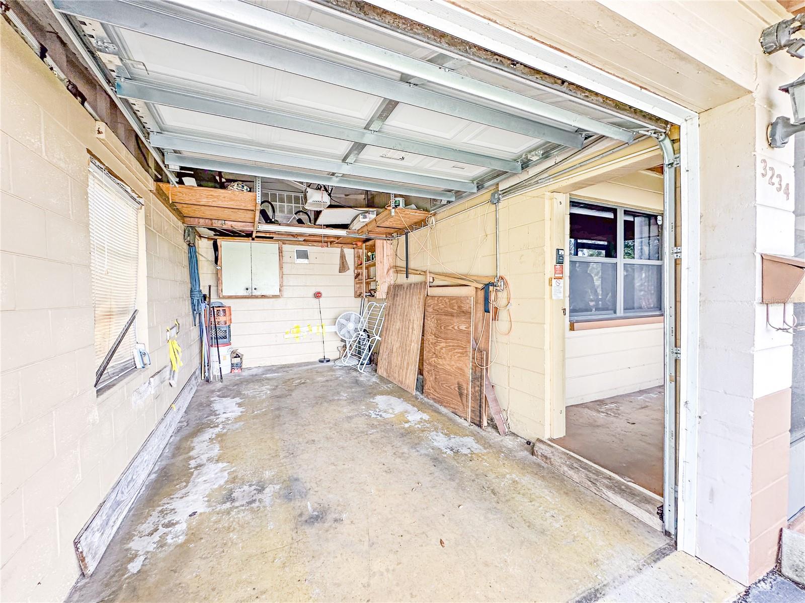 Garage with door to enclosed screened front porch