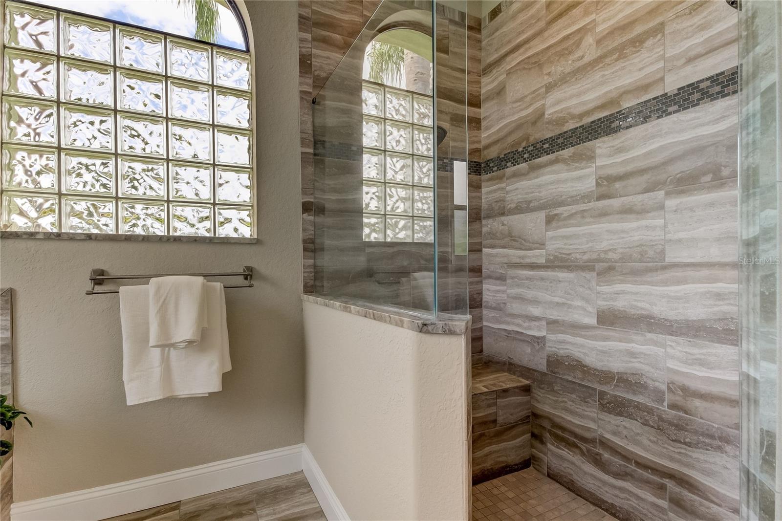 Owner's bath double shower heads, tiled seat.