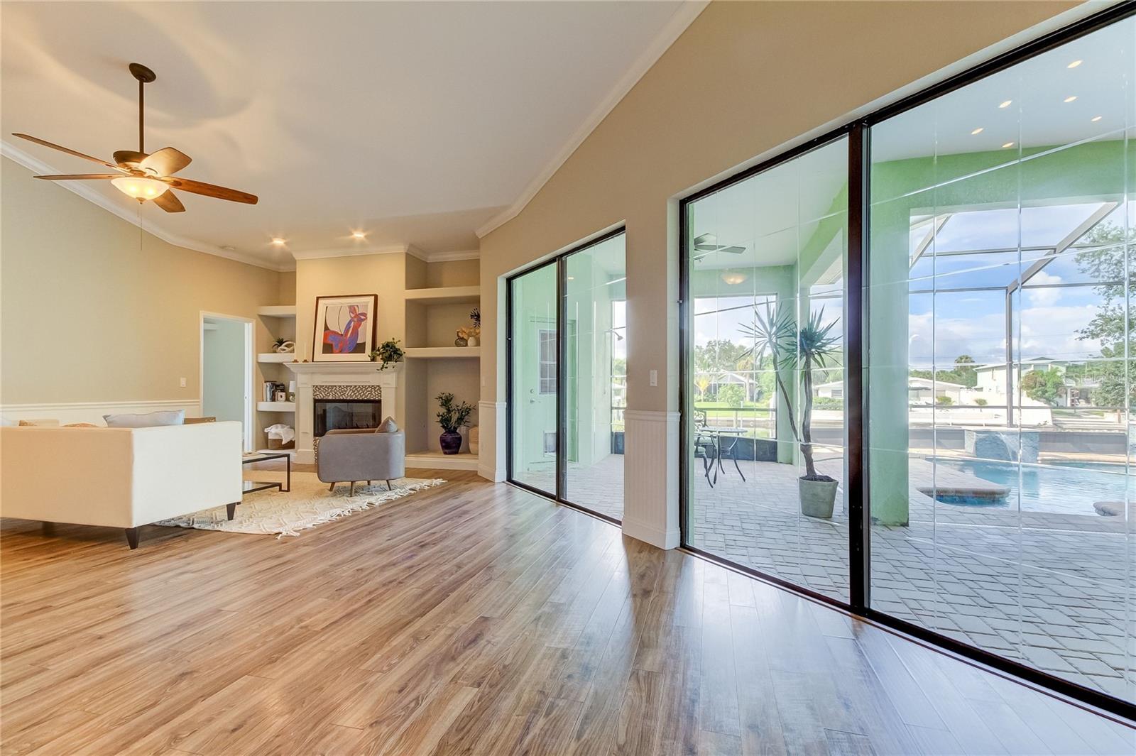 Living room sliders open to the lanai, pool and canal.