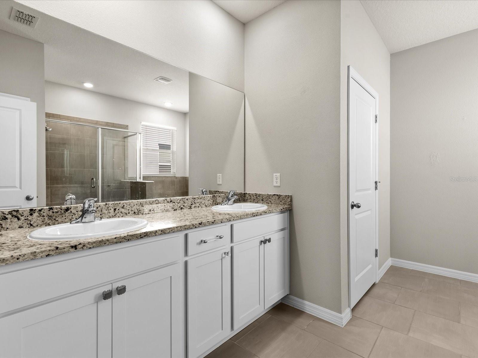 Primary Ensuite Bath featuring Dual Vanity and private Water Closet