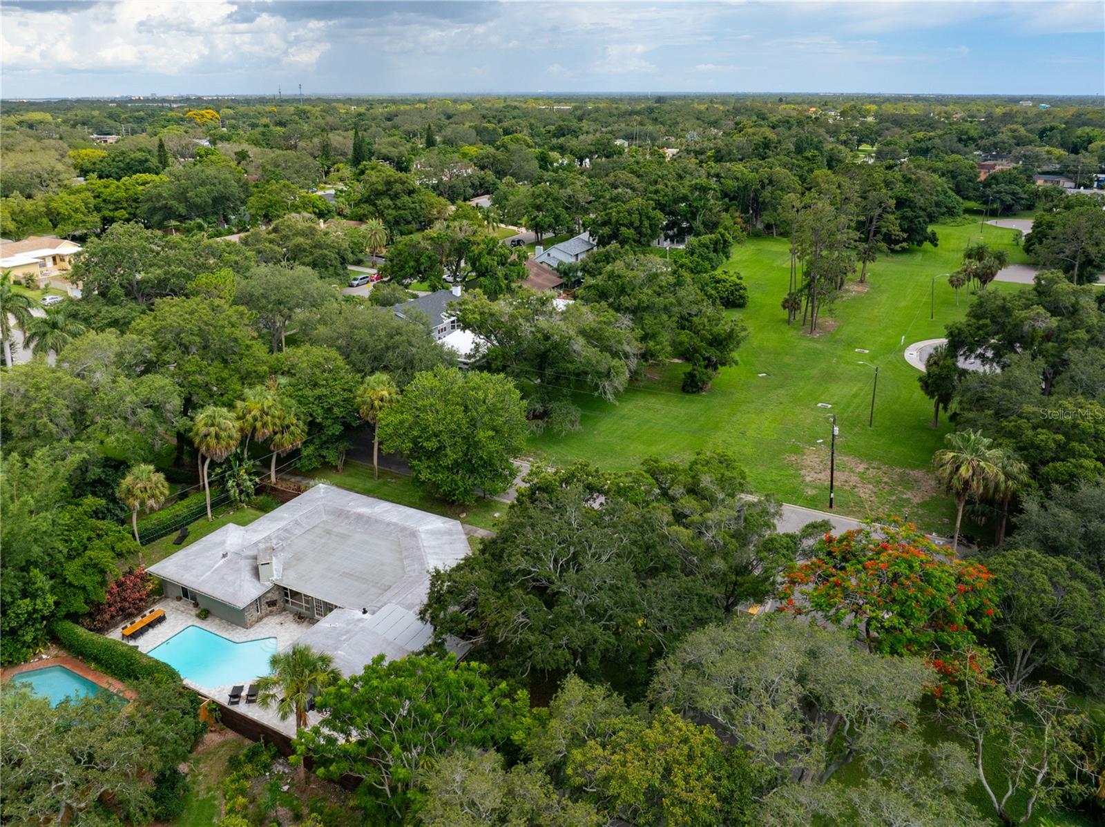 Aerial shot of the back of the house and the front park. Glorious shady trees everywhere.