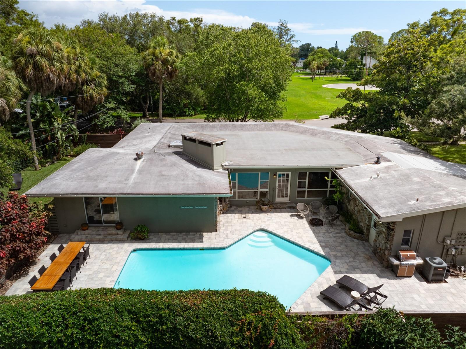 Aerial shot of the back of house and paved area.