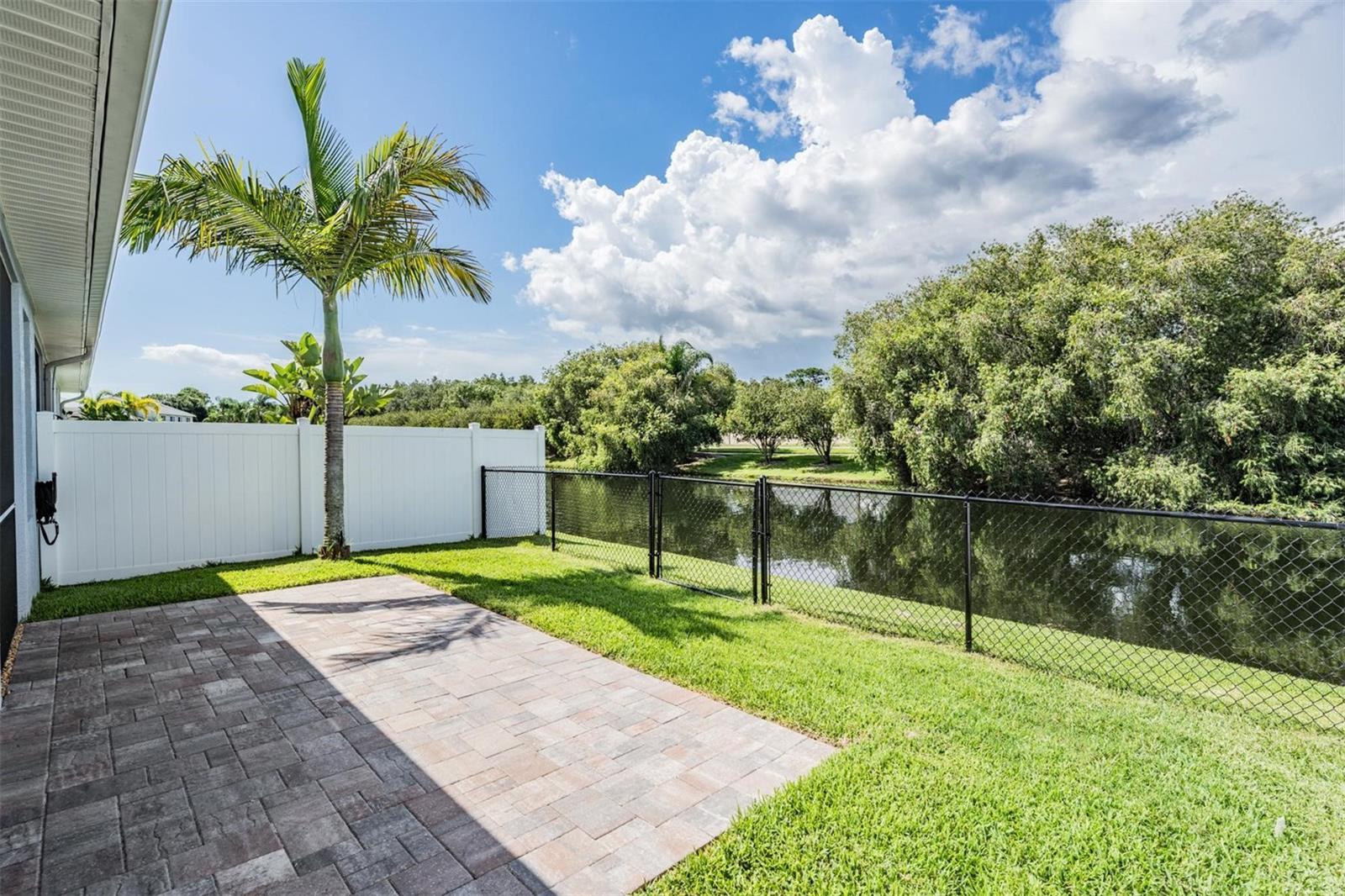 Fenced backyard w/grassy areas