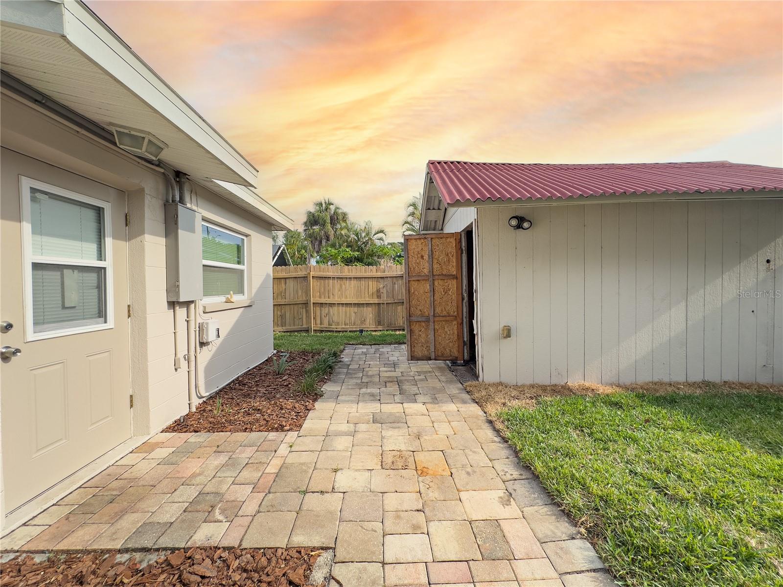 View of entrance of ADU on the left and man/woman cave on the left, with pavers throughout the home