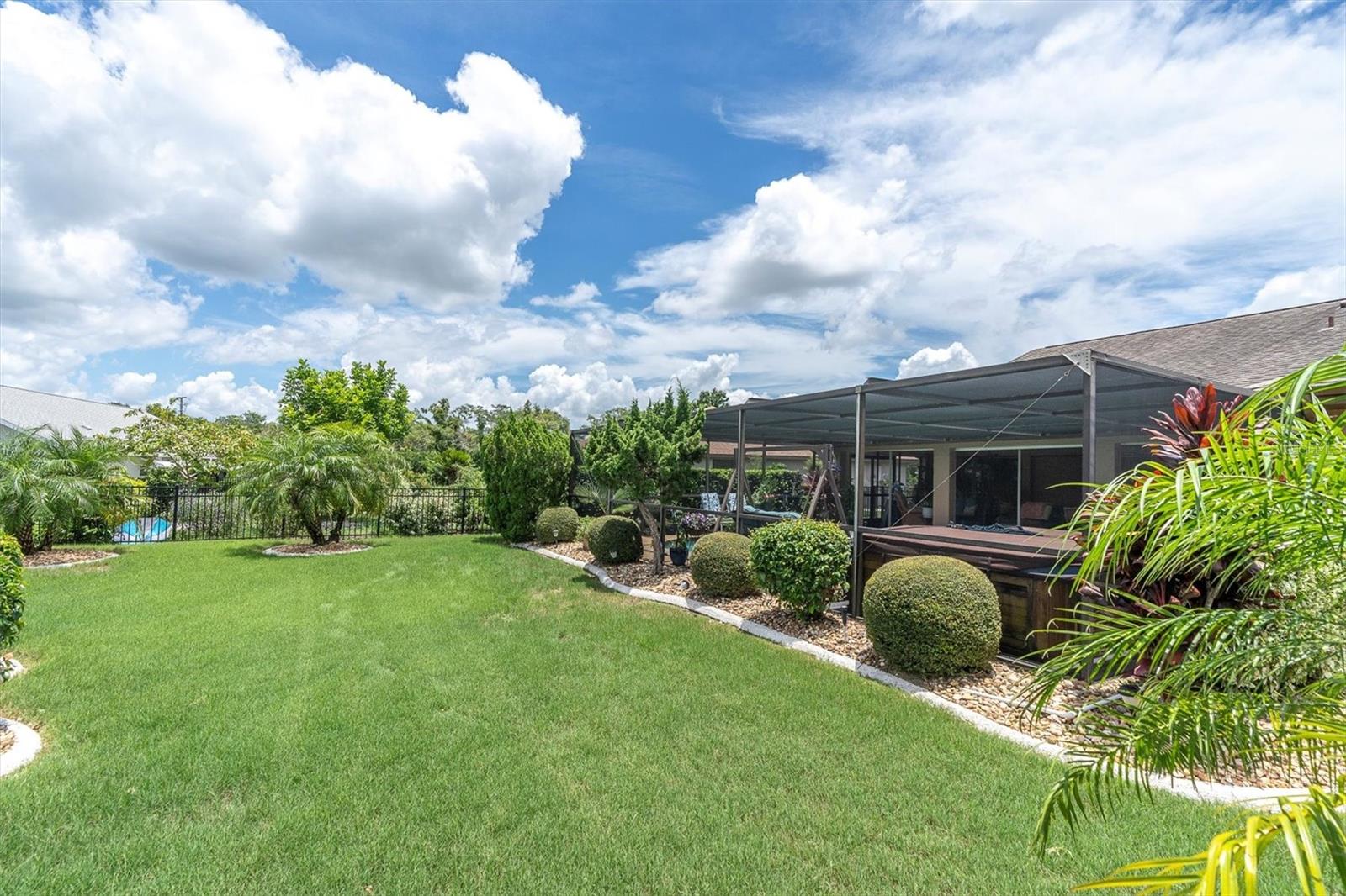 Manicured backyard with black iron fencing