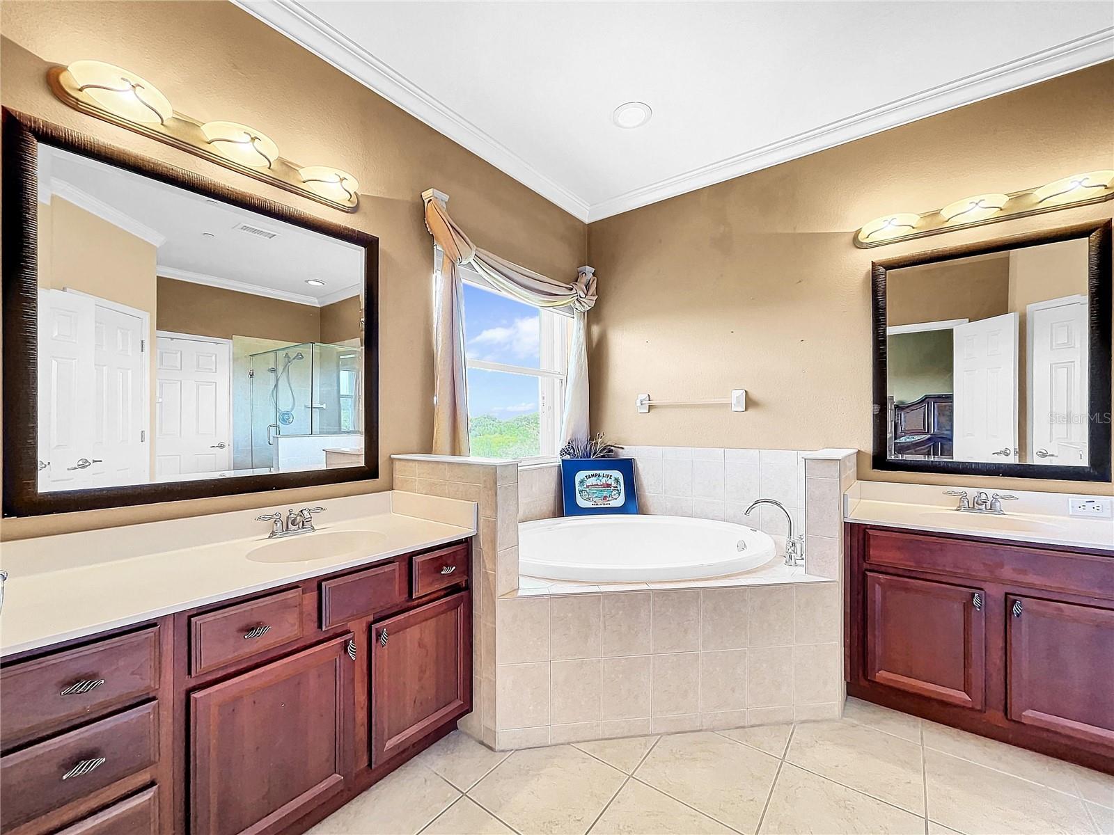 The master bathroom provides a soaking tub and separate sinks.