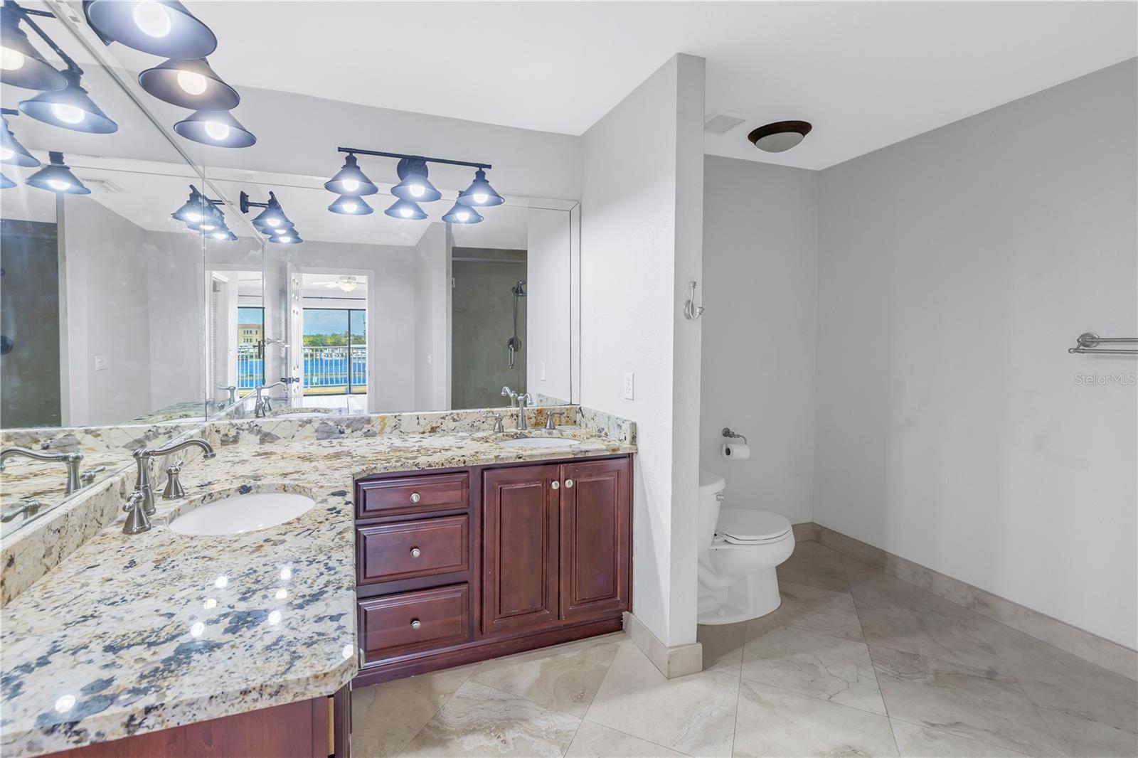 Primary bathroom with tile and granite countertops.