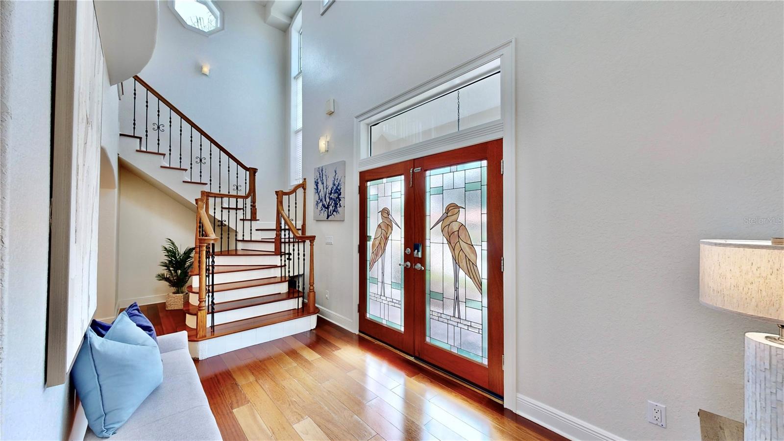 Enter through a bright and spacious foyer featuring soaring ceilings that offer an inviting and expansive atmosphere! Stained glass doors add to the beauty of this tranquil home.