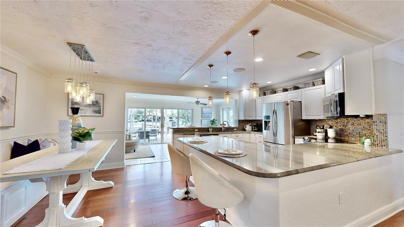 Gorgeous waterfront & pool views from the Kitchen & Dining room.