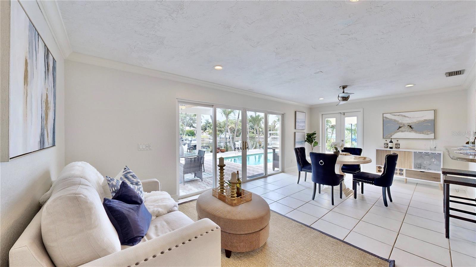 Serene waterfront & pool views from dining room/ living room.