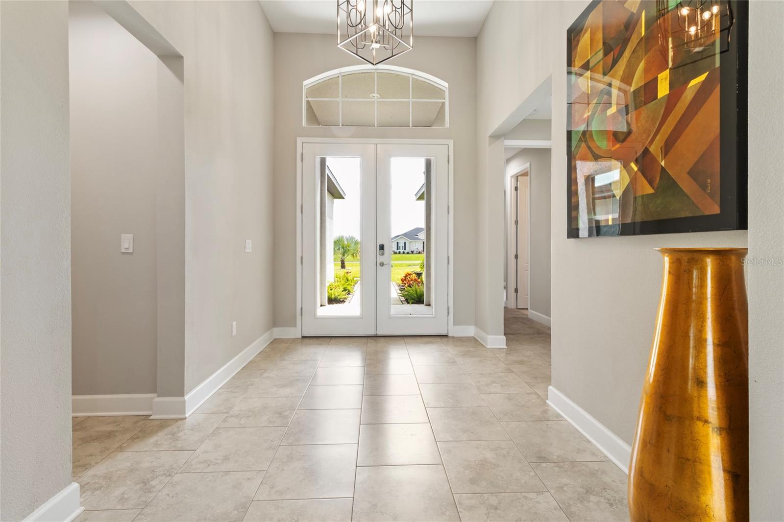 Grand Entry Foyer features Glass French Doors and palladium transom for natural light.