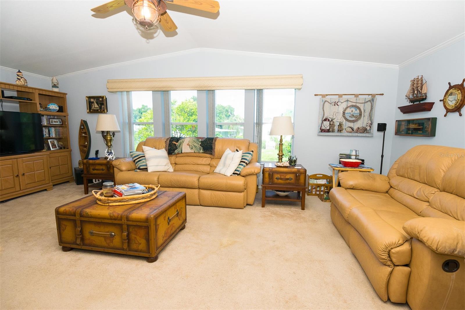 Great room with vaulted ceiling and view of landscaped lot nextdoor