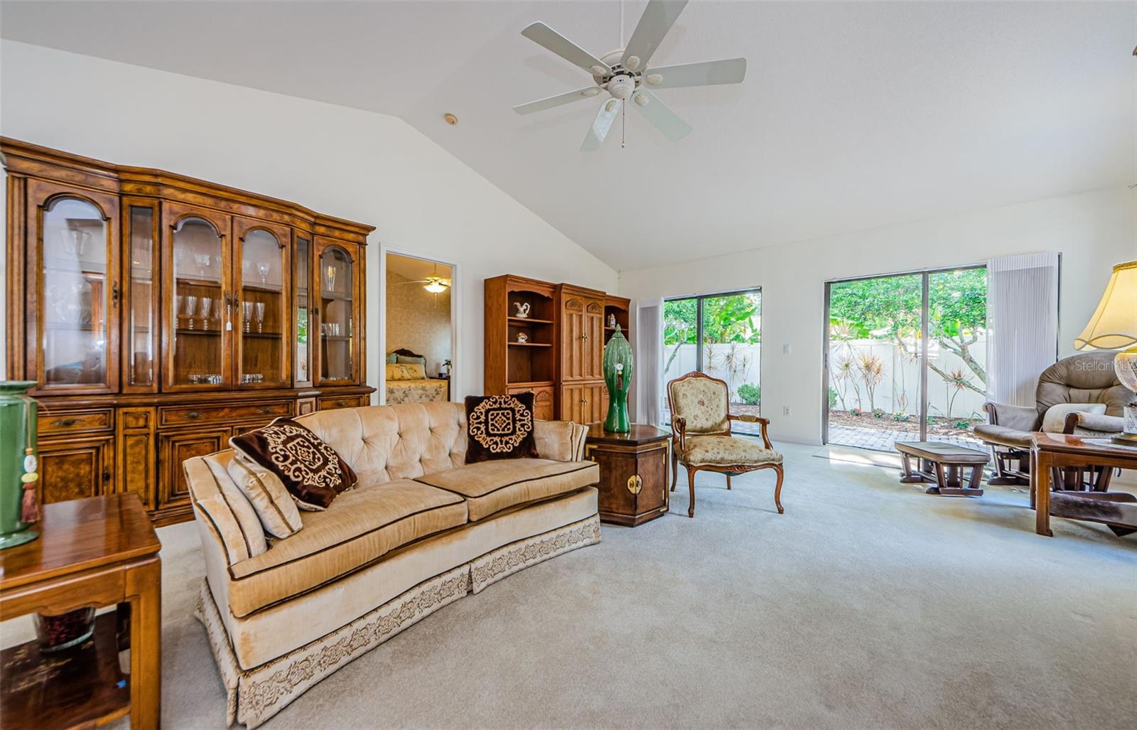 Spacious living room area with vaulted ceiling and sliding doors to the back patio area. So much light and privacy!