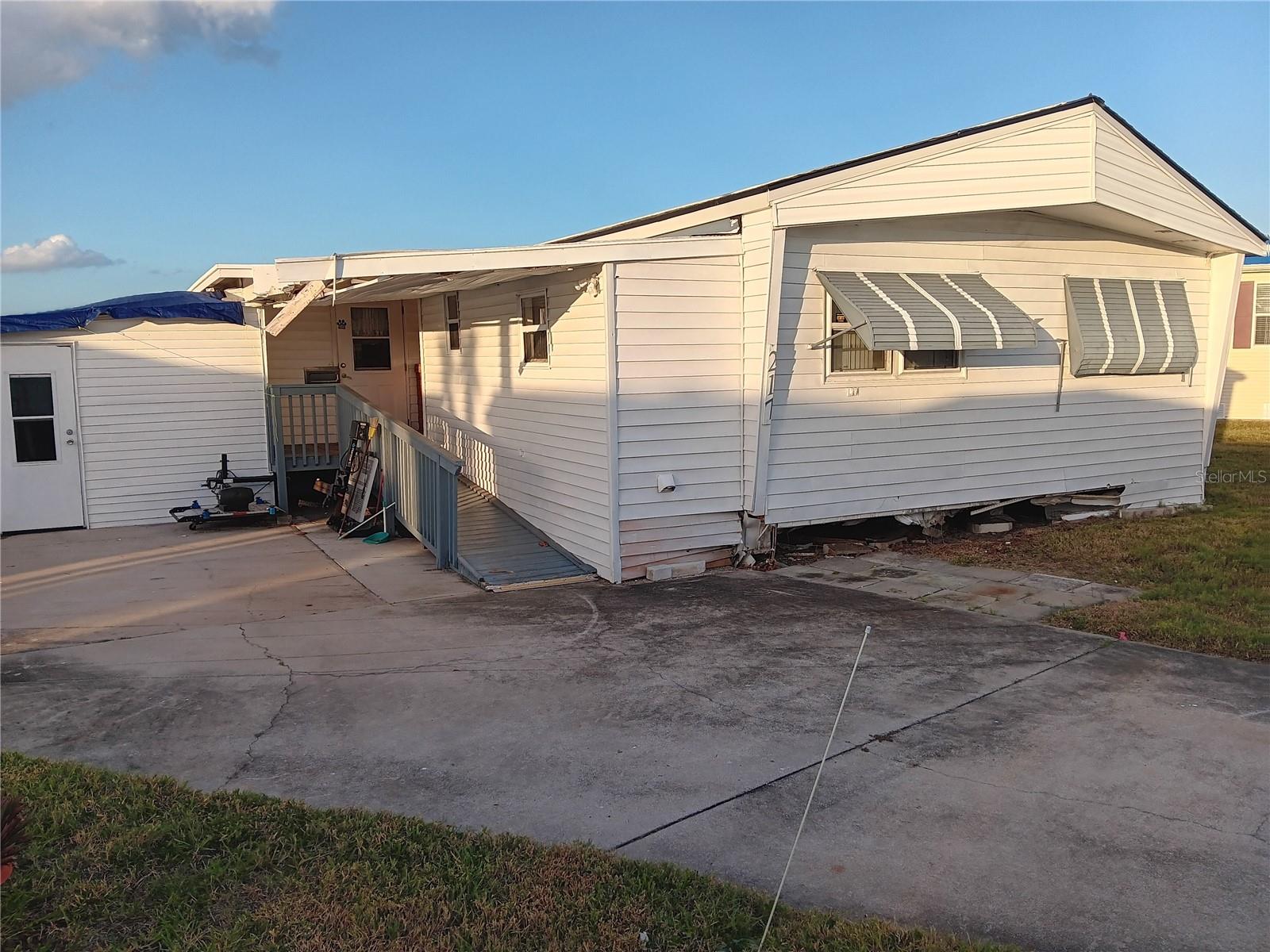 Front of the house with exterior siding damage.