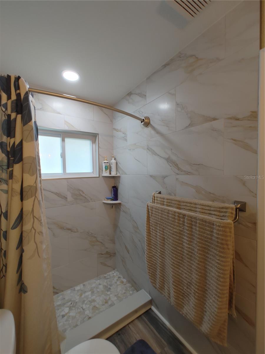 Master bath is beautifully remodeled with all neutral earthy tones, large ceramic tiles go all the way to the ceiling.