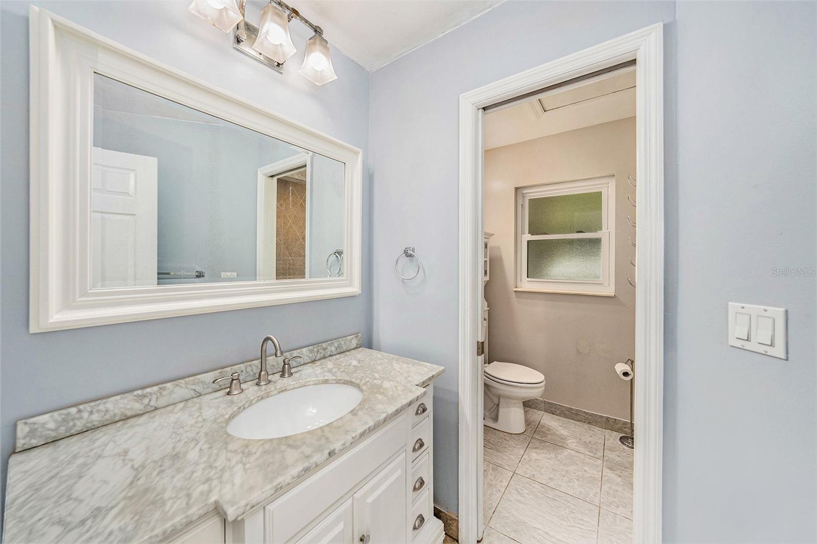 En suite with sink and vanity separated from shower with pocket door.