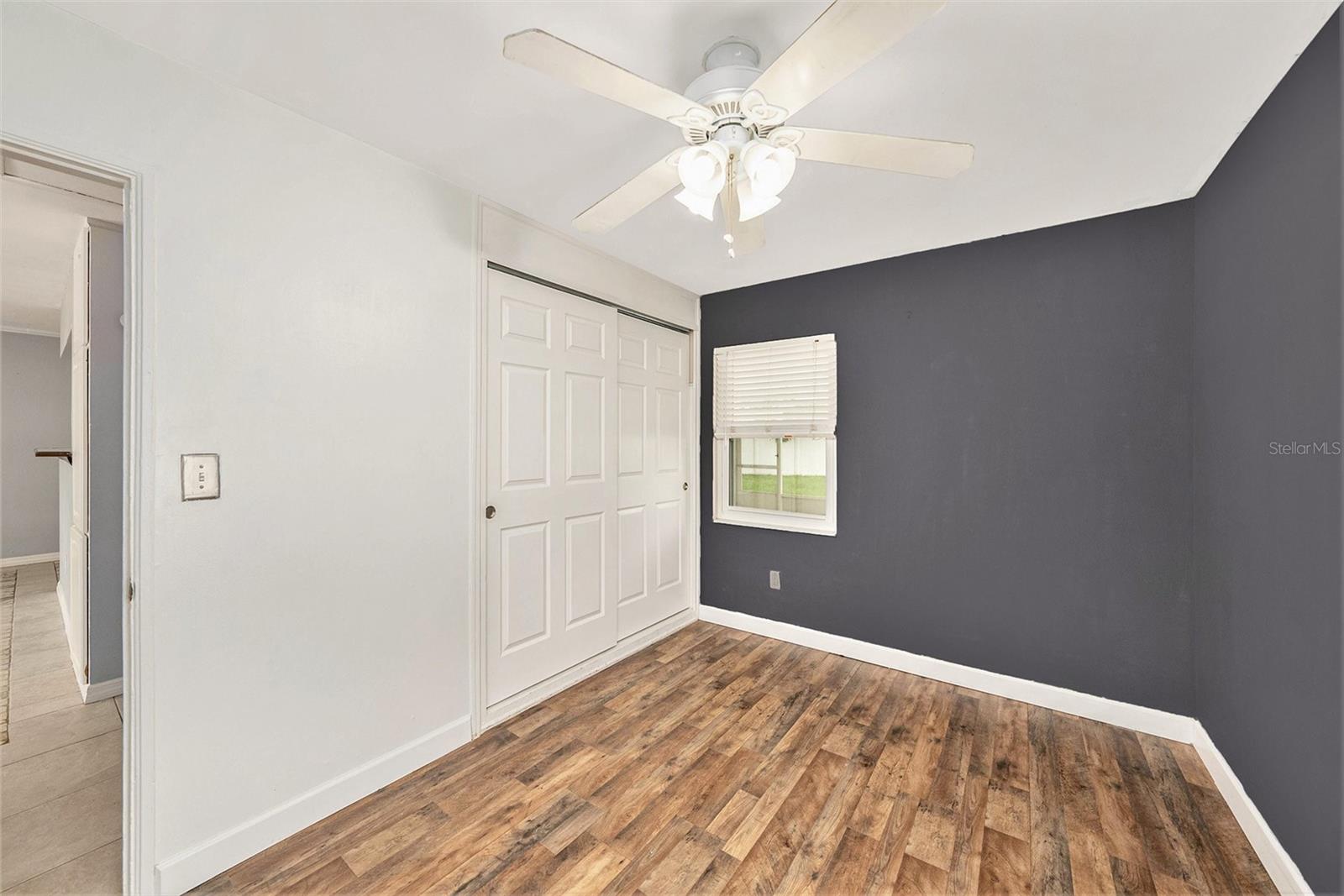 Bedroom 2 with ceiling fan and accent wall.