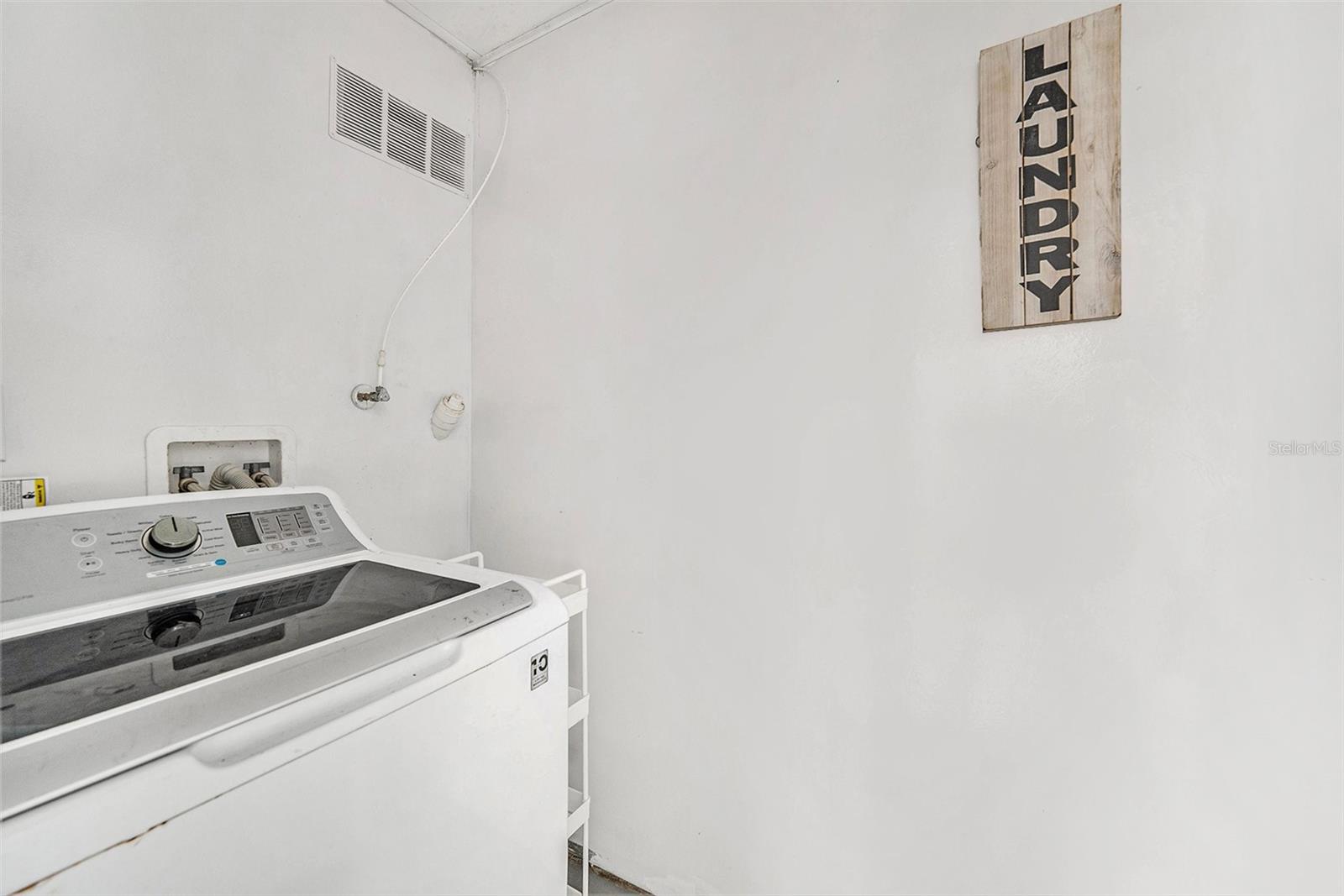 This cute little laundry room is located just off the carport.