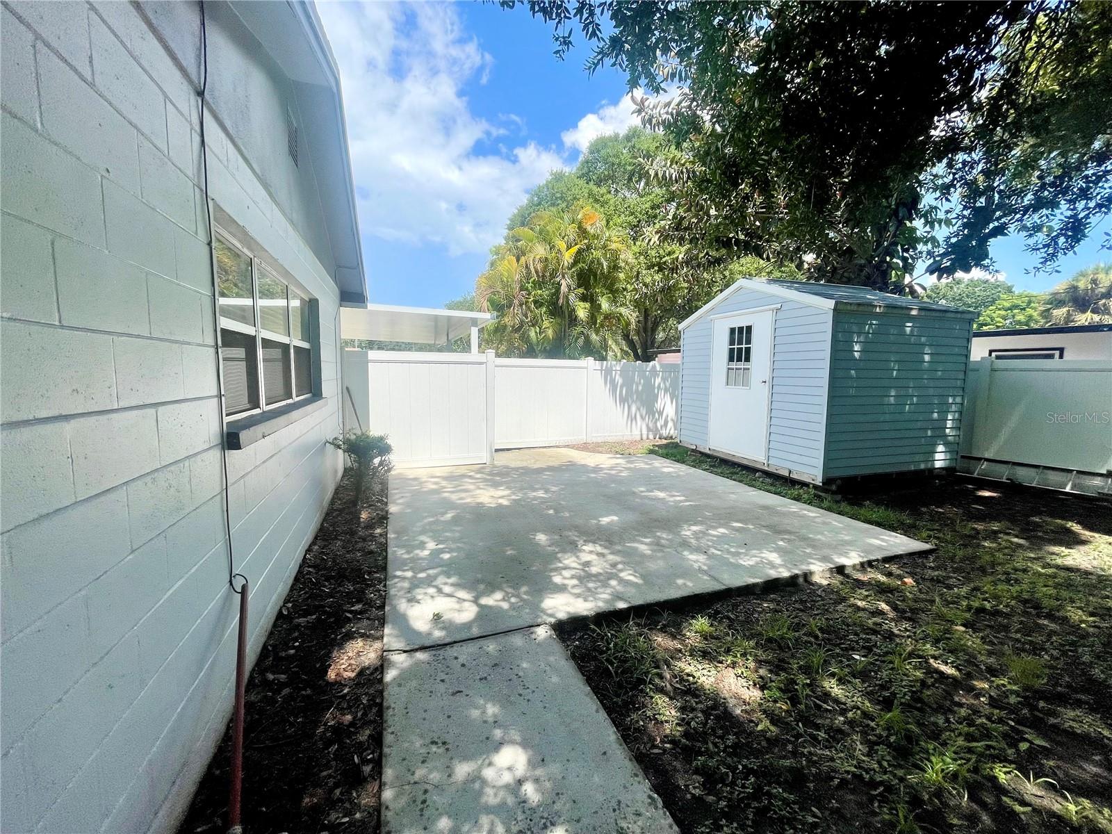 Storage shed tucked away in the backyard near driveway