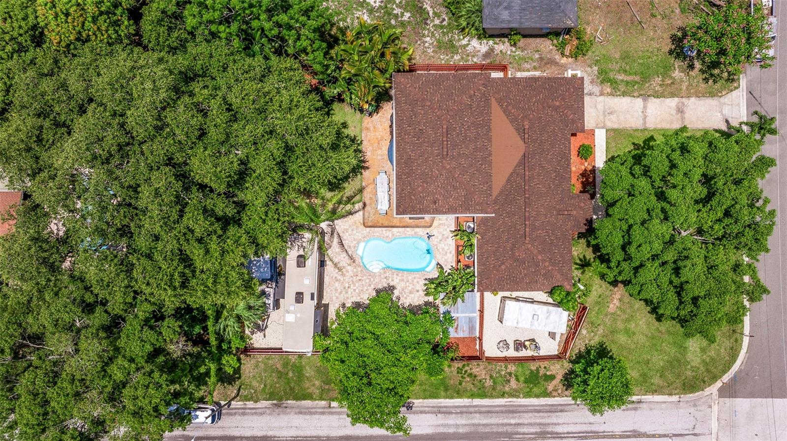 Aerial view of the home. On the bottom left there is a large graveled parking area with enough room for 2 RV's, 2 boats, or one of each. On the bottom right is another graveled parking pad for a trailer or other toys.