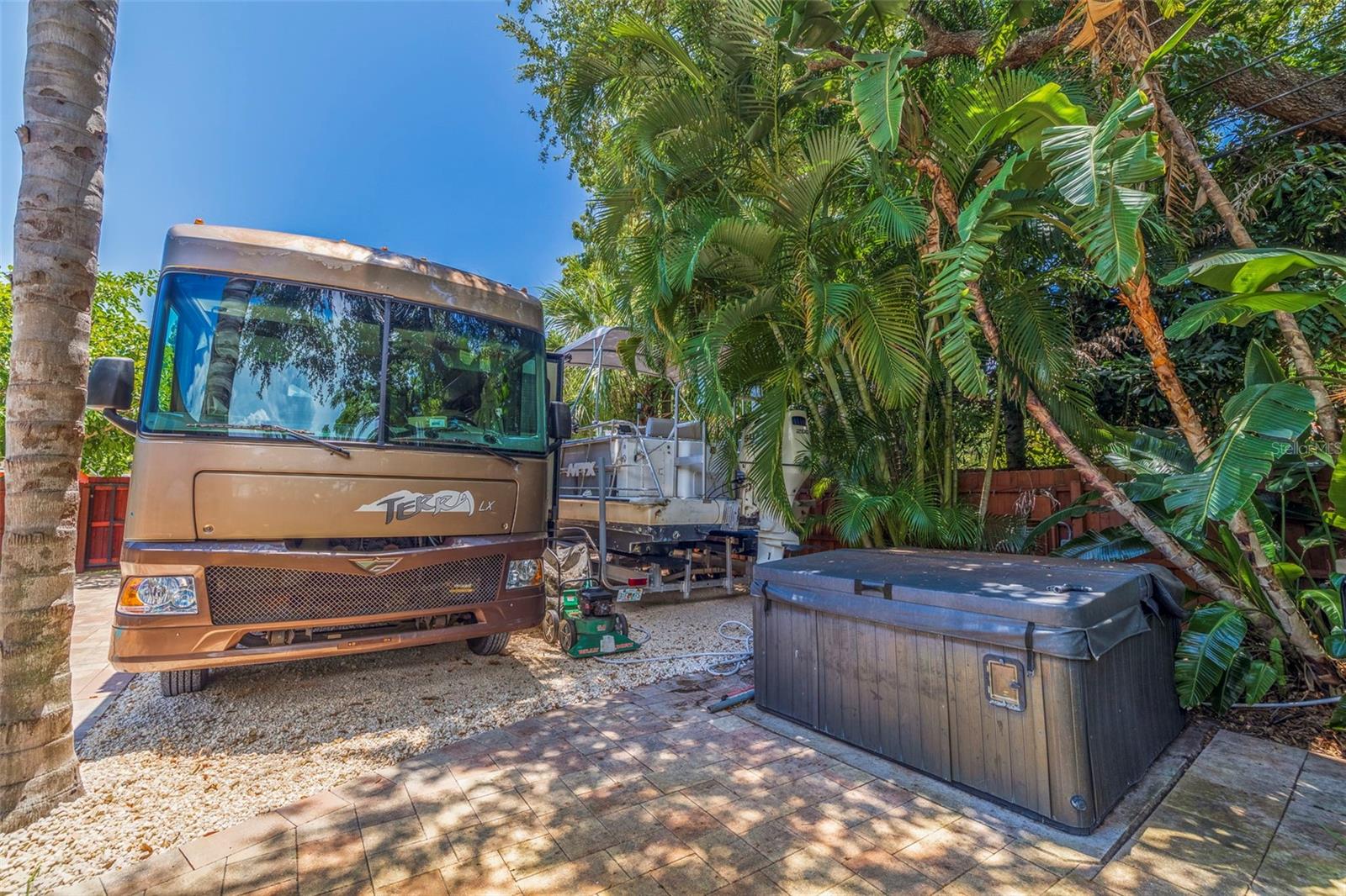 Graveled parking area and hot tub in backyard