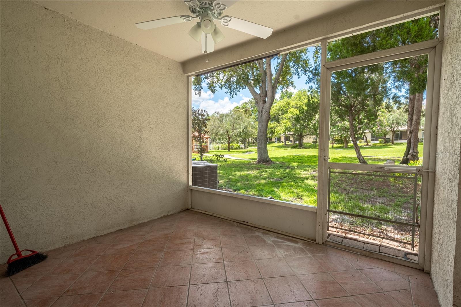 The living room has sliding glass doors that open to the back porch which has a tiled floor and ceiling fan.