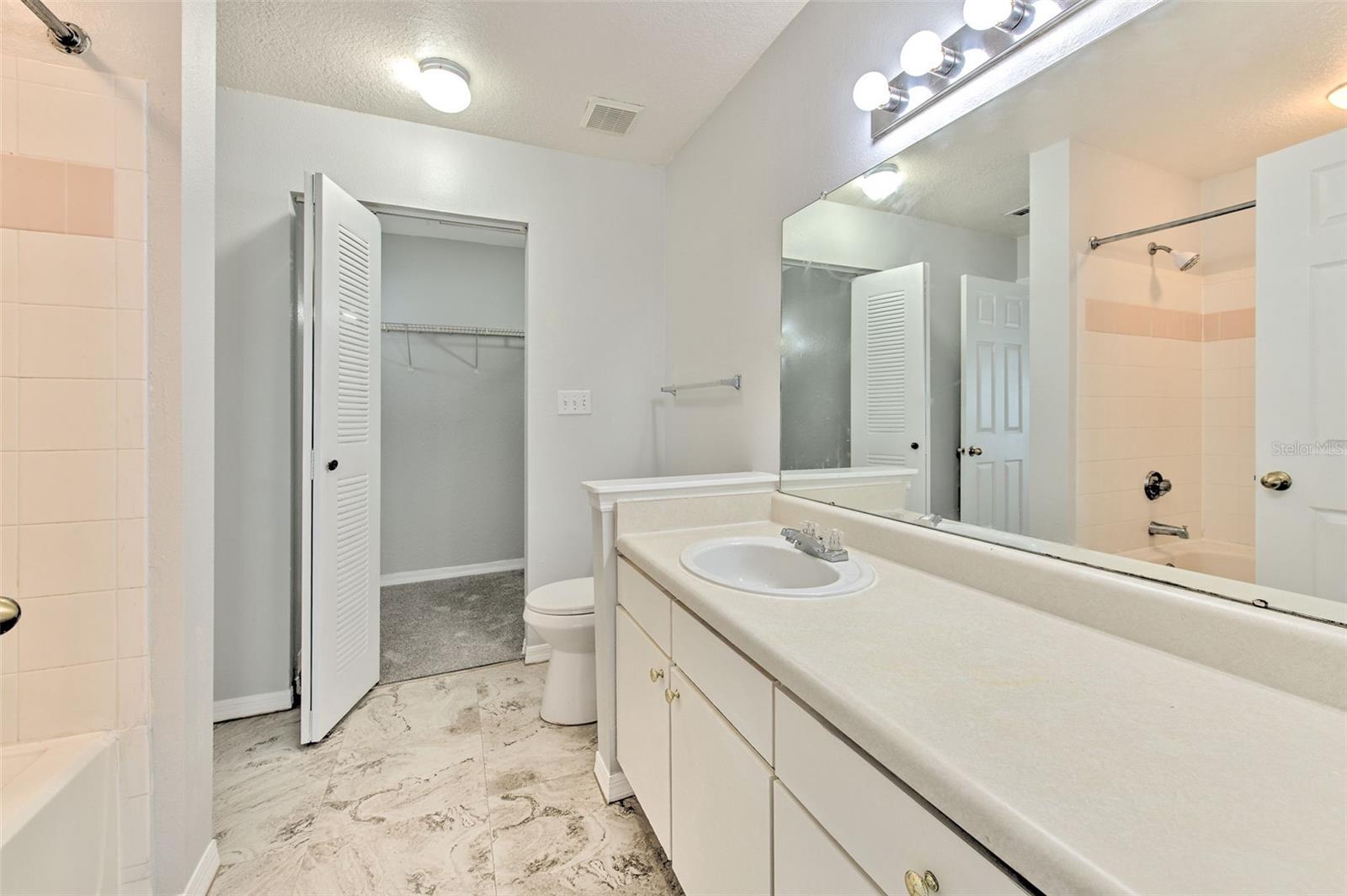 large bathroom with long cabinet and tub