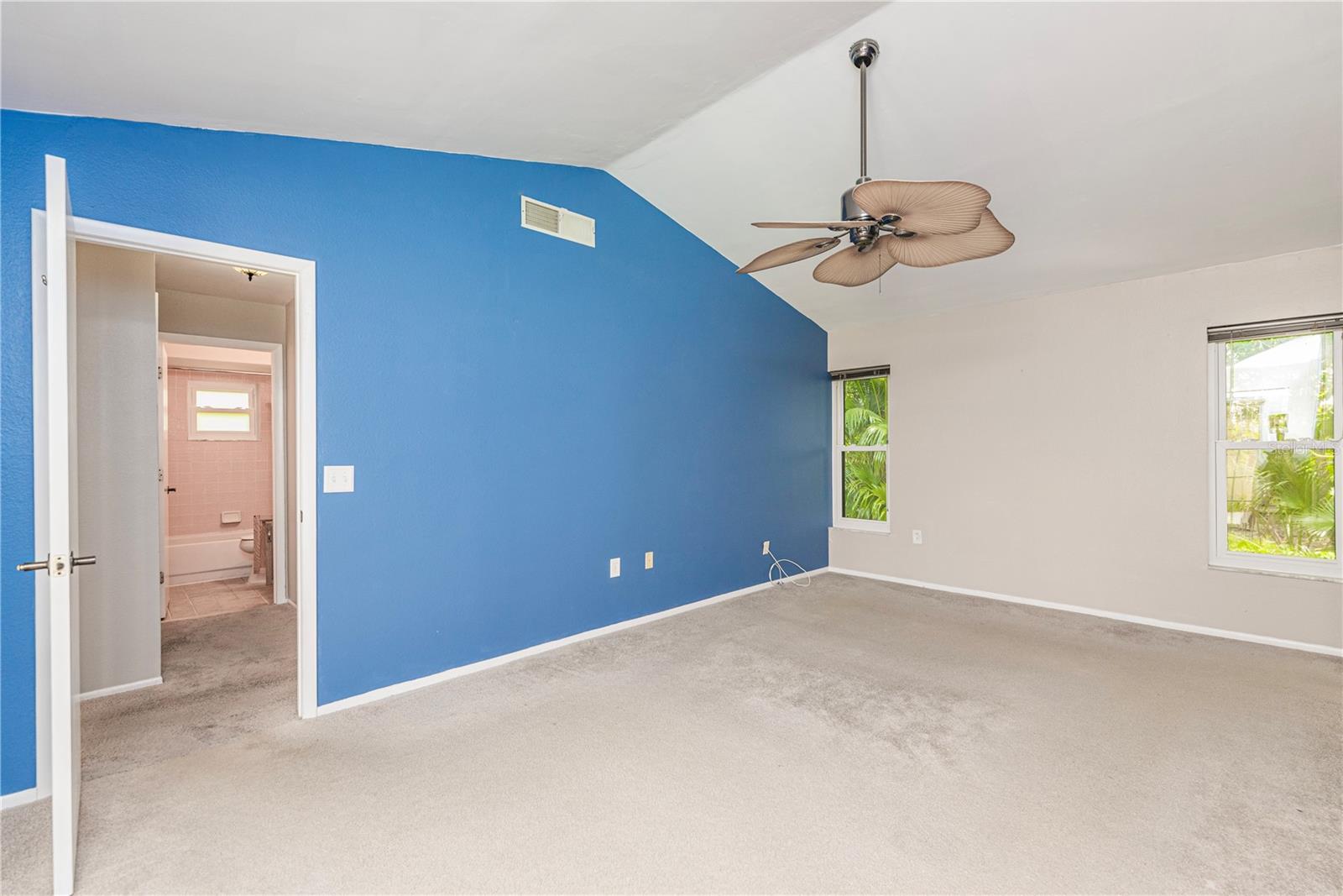 Primary bedroom with vaulted ceilings.