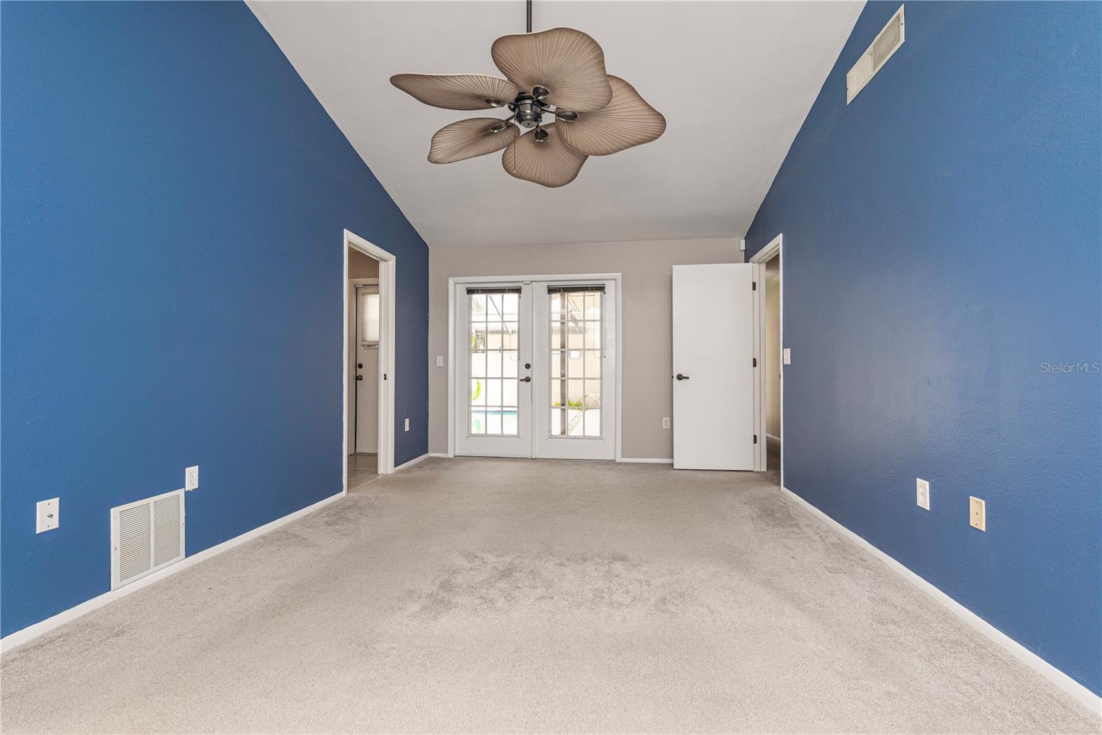 French doors leading to pool lanai from primary bedroom.