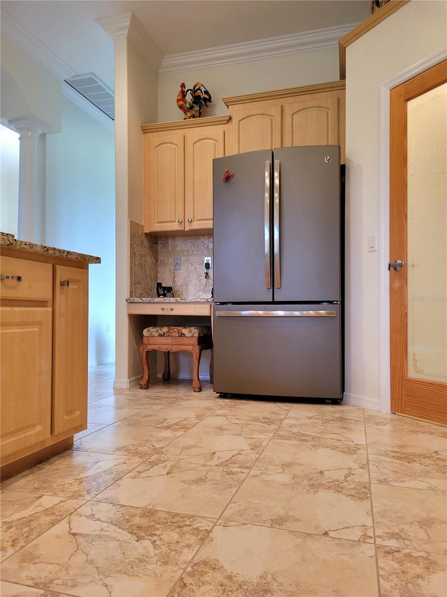 View 4, showing a close-up of the Travertine tile flooring, the GE, Double Door Fridge with Bottom Freezer & Walk-In Pantry on the right