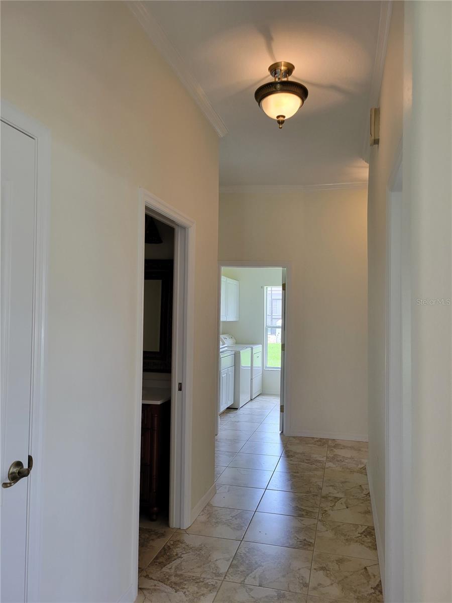 Hallway right of Entry Foyer looking toward 1/2 Bath to left and Laundry Room beyond