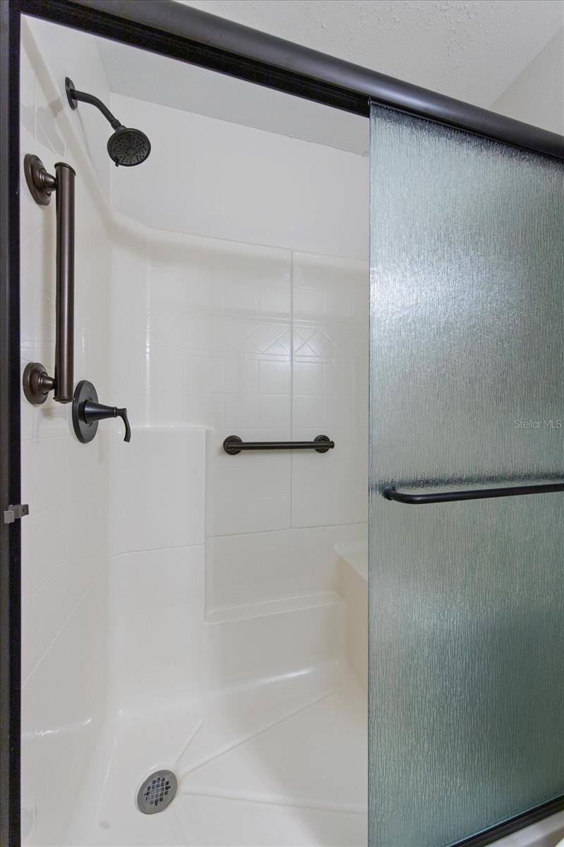 Guest bathroom update included shower with bench, safety bars & sturdy glass doors~