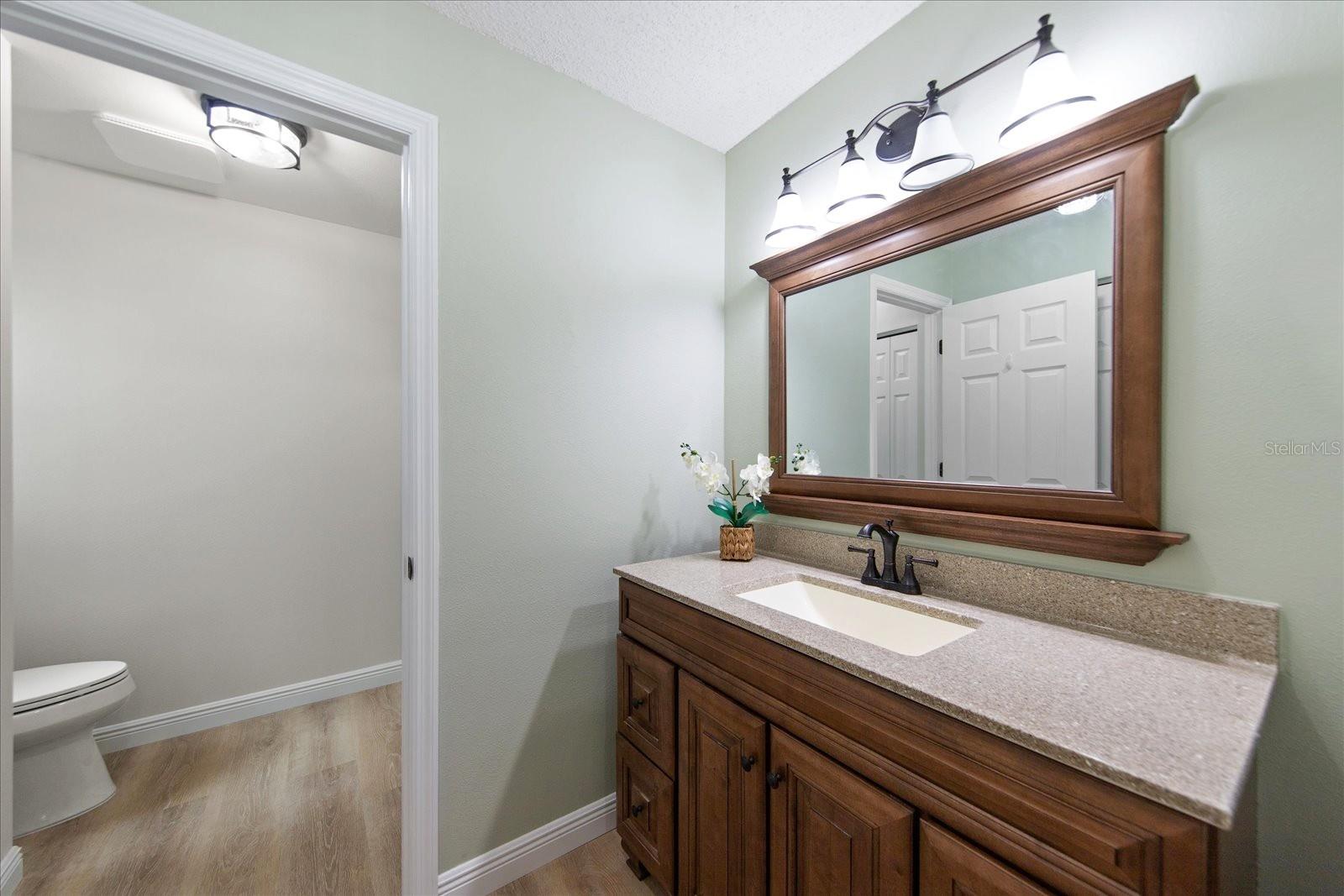 Updated wood vanity with matching mirror & solid surface counter~