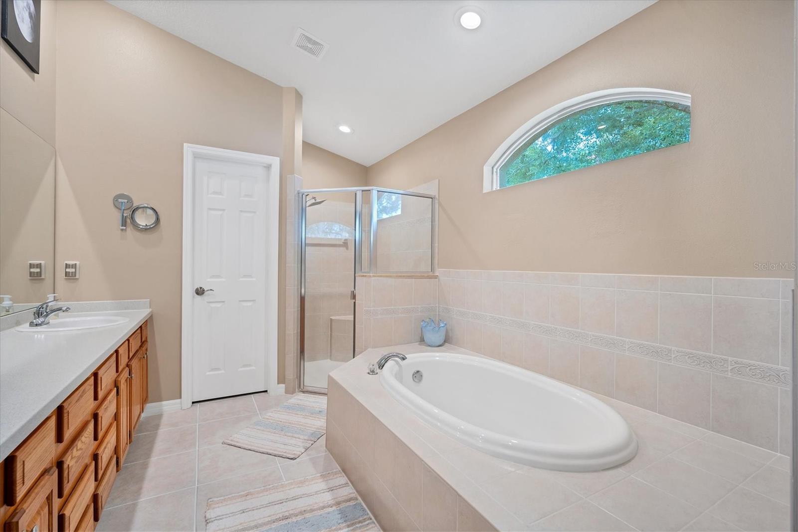 Oversized en-suite bath features a private water closet, deep soaking tub and a walk-in shower