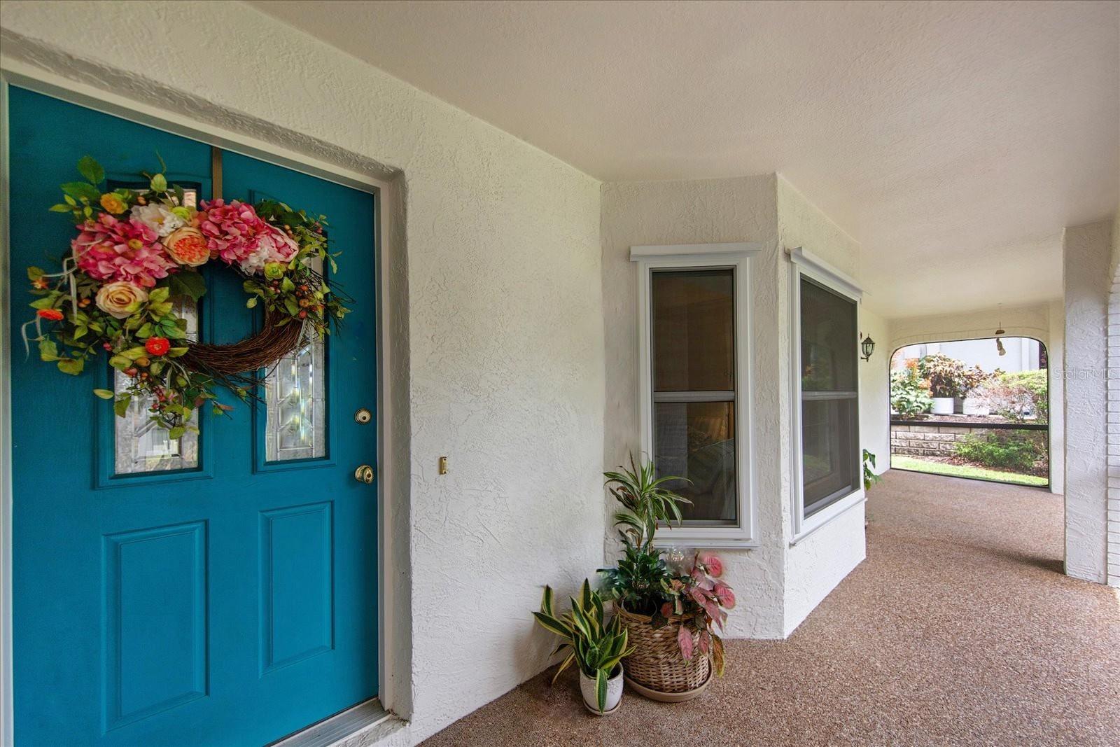 The gracious front door is protected with a covered & screened lanai~